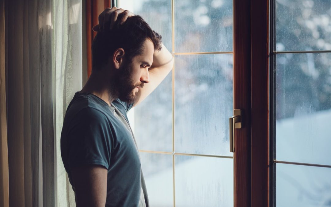 Man-looking-depressed-while-watching-rain