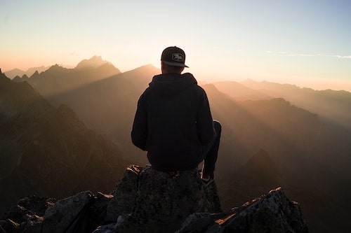 man looking at mountains at sunset